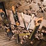 Close Up of Woodworking Tools on Wooden Table Surrounded by Wood Shavings
