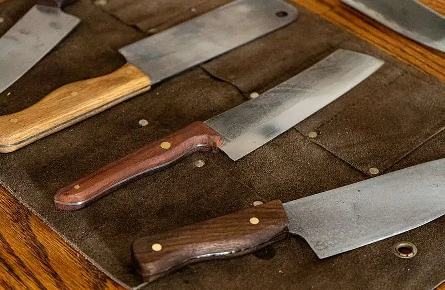 custom knives with wooden handles on sheet of leather