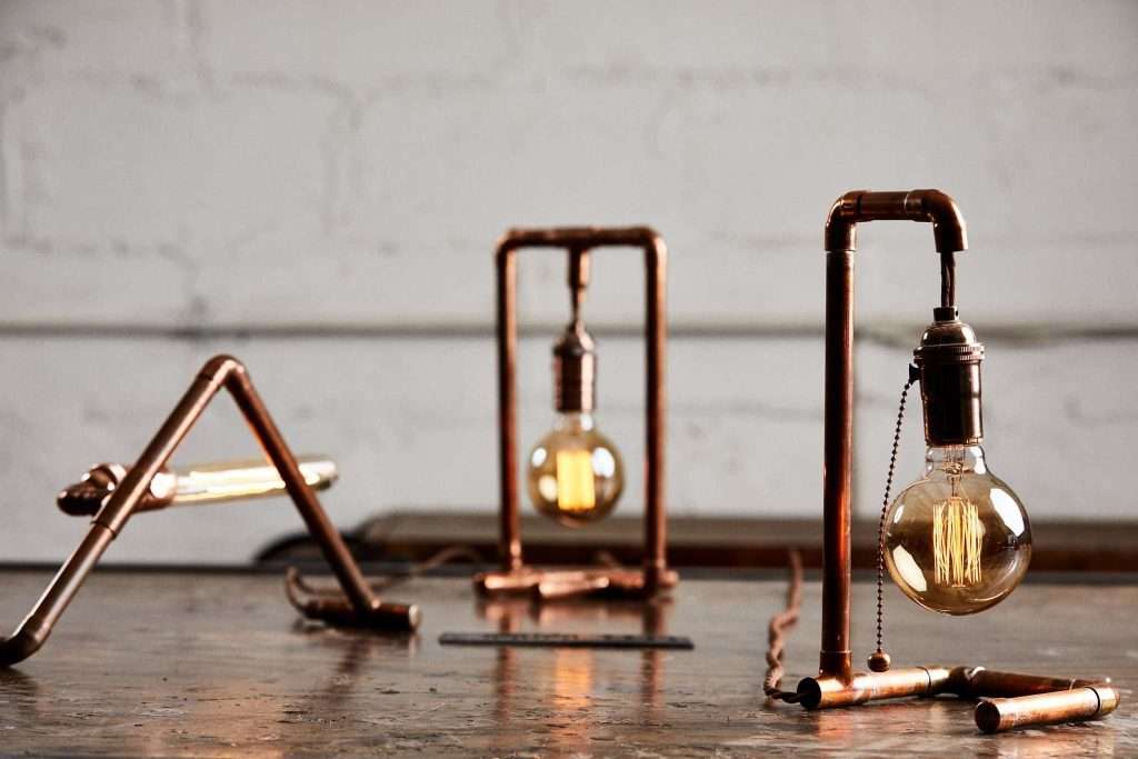 3 custom lamps in different shapes made out of copper pipes made at a Craftsman Ave workshop