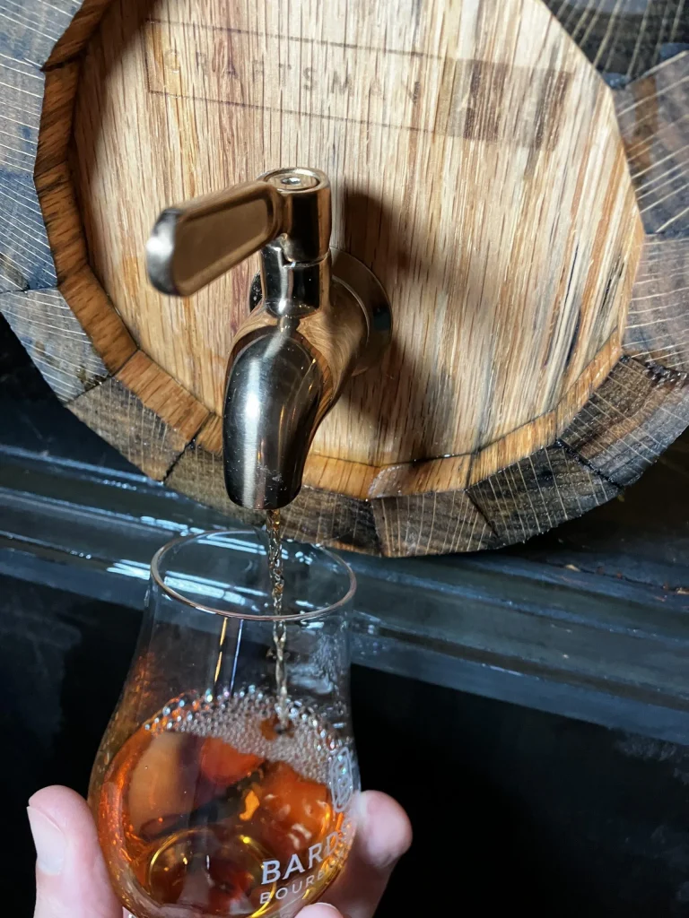 Whiskey Barrel from Craftsman Ave's Woodworking Class with Hand Pouring Whiskey into Glass