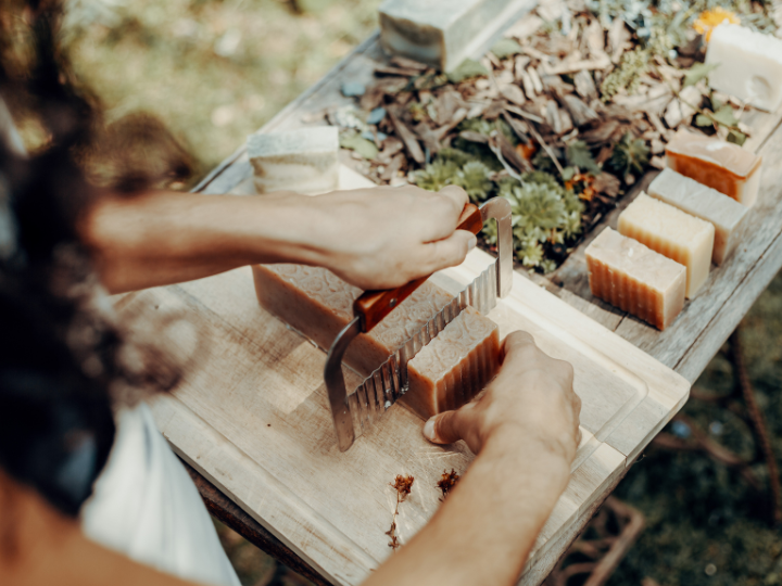 A woman cuts a bar of homemade soap