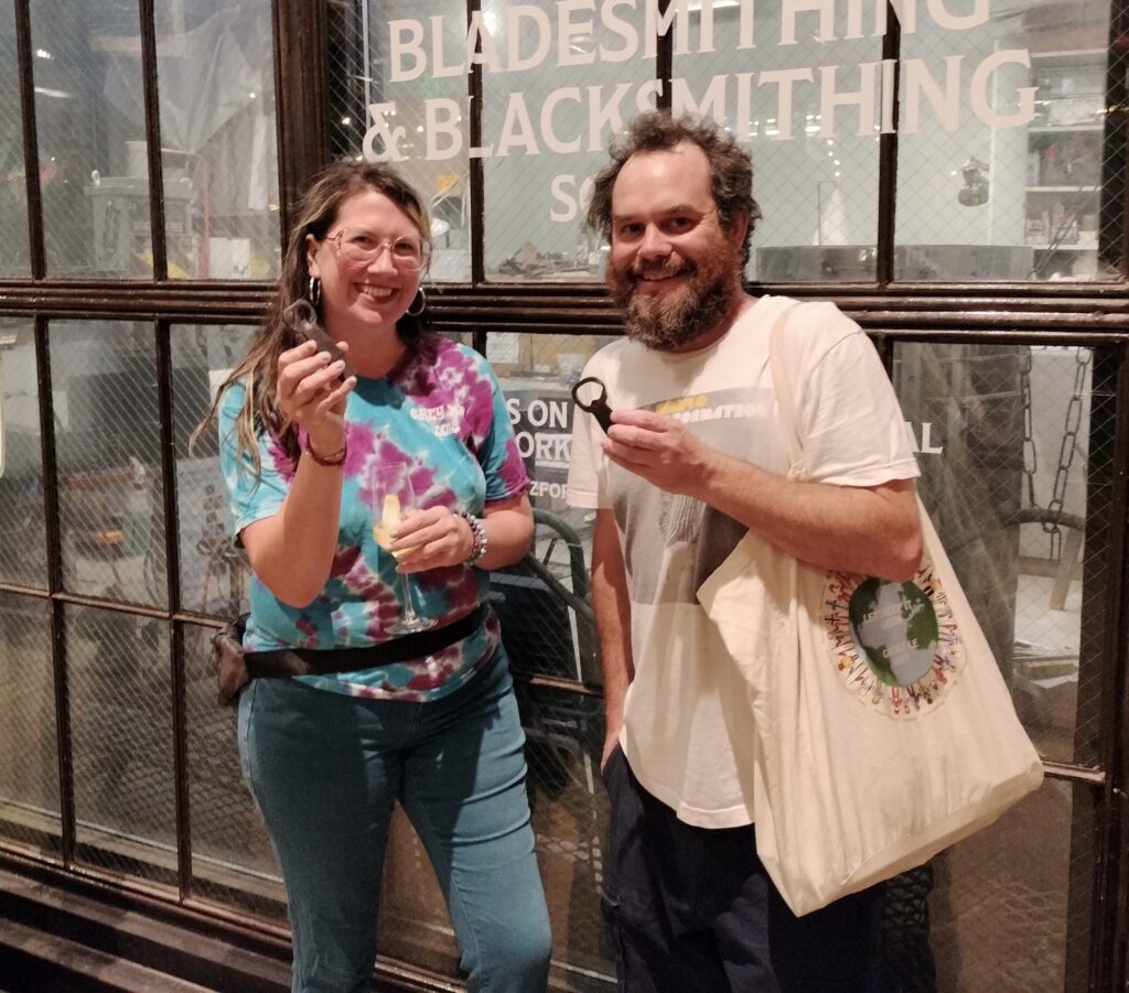 Two people showing off their handmade bottle openers.